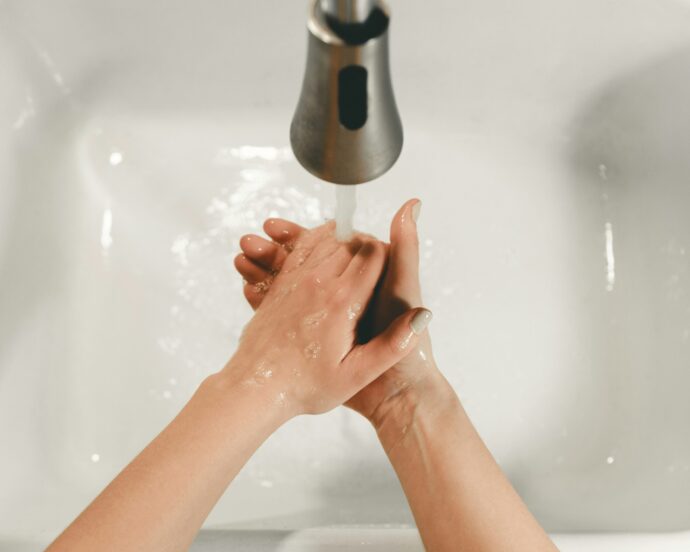 水道で両手を洗う
