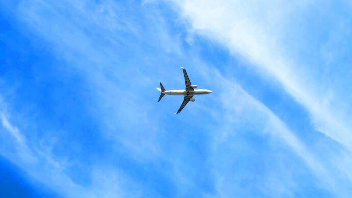 青空に飛ぶ飛行機の様子