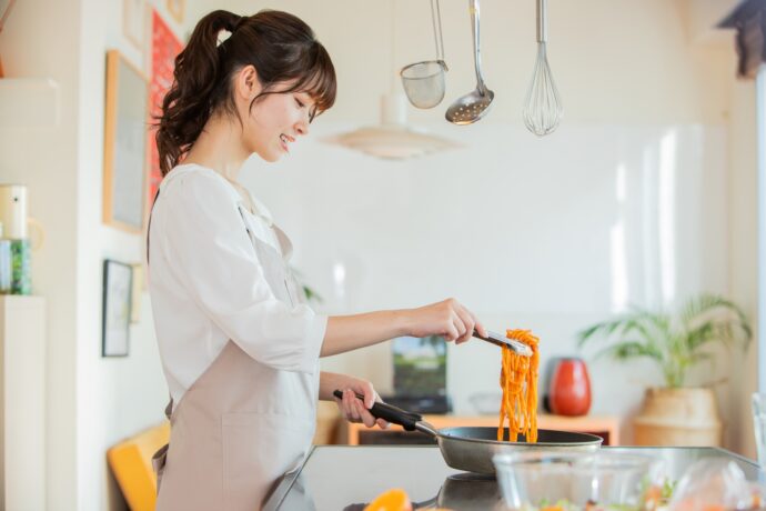 フライパンで料理中の女性